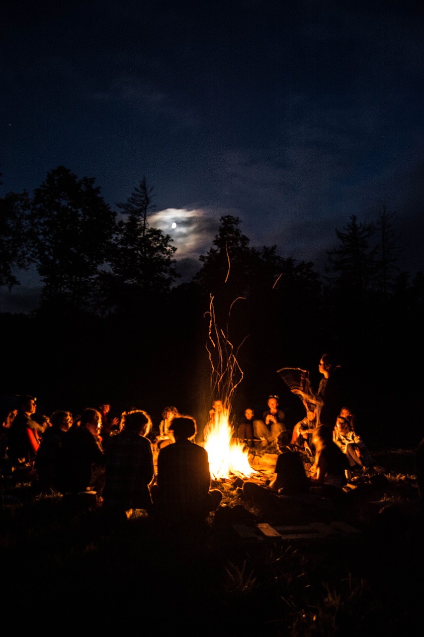 a group of people around the campfire