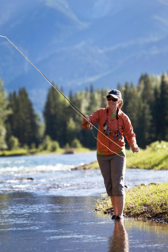 a woman fly fishing in a remote river in wyoming